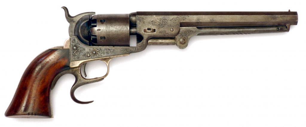 A side view of a Colt Navy model revolver, with engraved decoration and a rare factory fitted finger rest for stability
